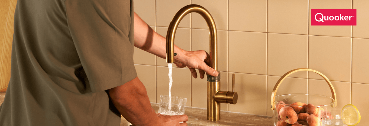 Close up of a patinated brass Quooker tap in use, the collar is being pumped to enable instant boiling water to be poured into a glass.
The Powerswitch 2.0 is Quooker’s latest innovation.