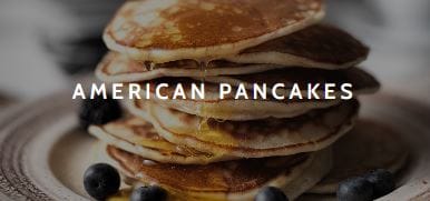 A stack of pancakes with blueberries and syrup.
