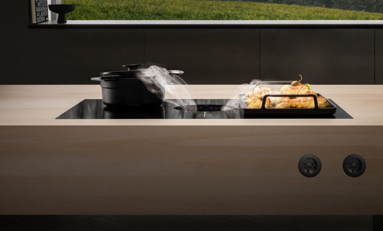 The BORA M Pure cooktop extractor demonstrating the central cooktop extraction with vapours and steam being drawn down away from the pans on either side.