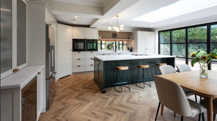 A spacious shaker style kitchen with an island breakfast bar separating the kitchen and dining space