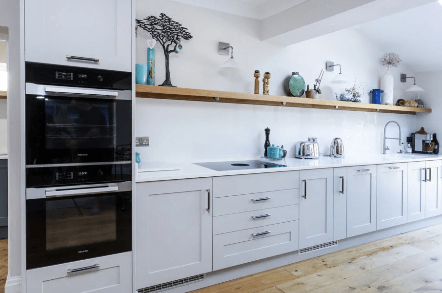 A bright shaker kitchen where the cabinetry, sink and main oven are all arranged on one wall.