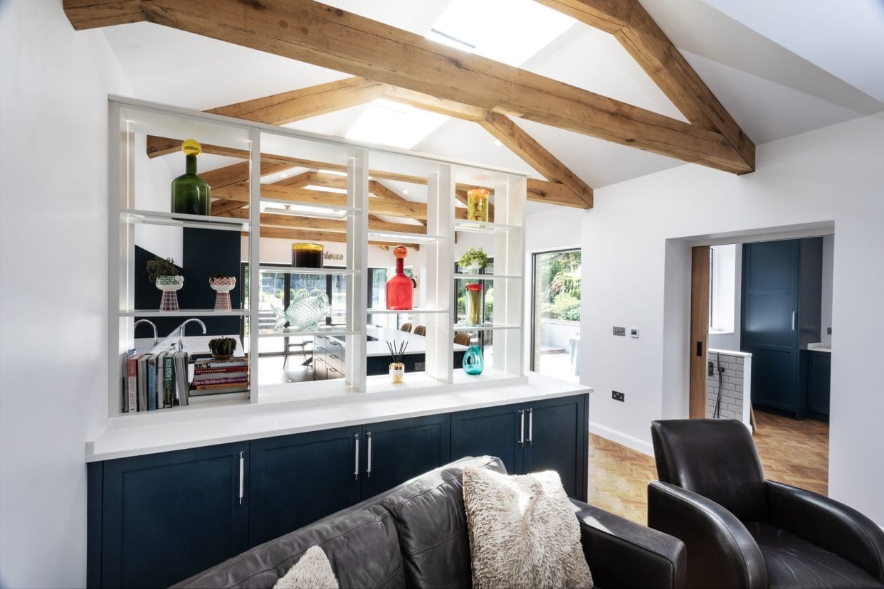 An open-plan kitchen / living space with white open shelving to divide the space.