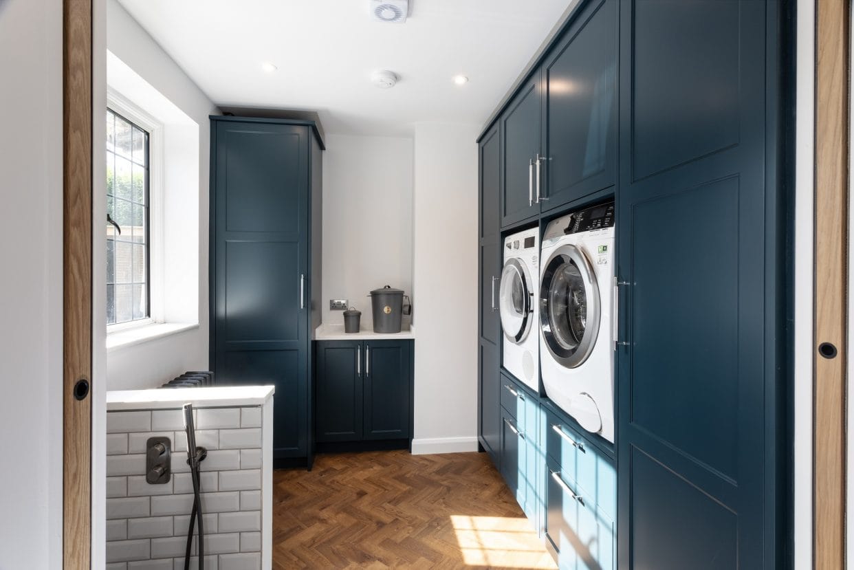 A smart, stylish utility room with eye-level laundry appliances and drawers below.