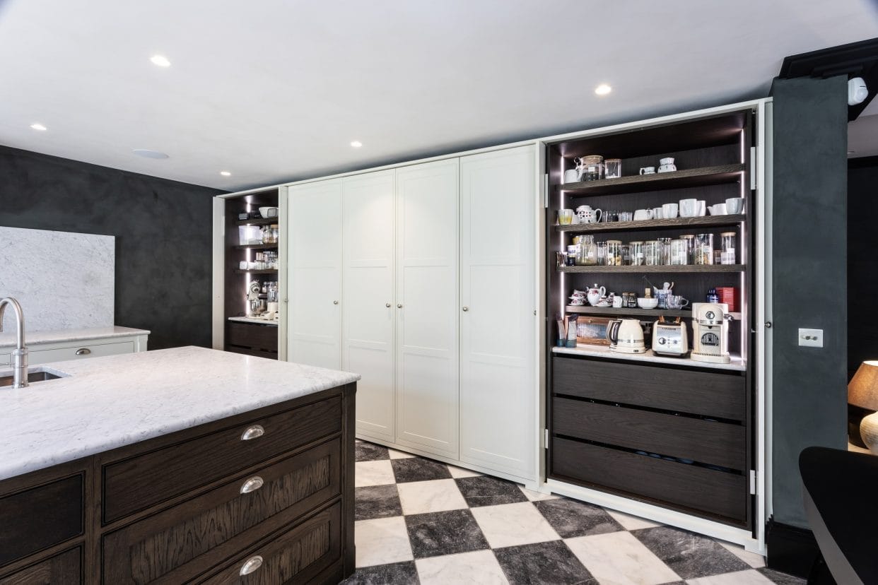 A wall of shaker cabinetry with a pantry at each end hidden behind pocket doors.